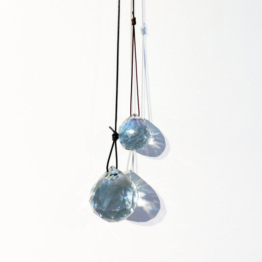 Kristallprismor på lädersnöre, färdiga att hänga i fönstret, skapar regnbågsfärger