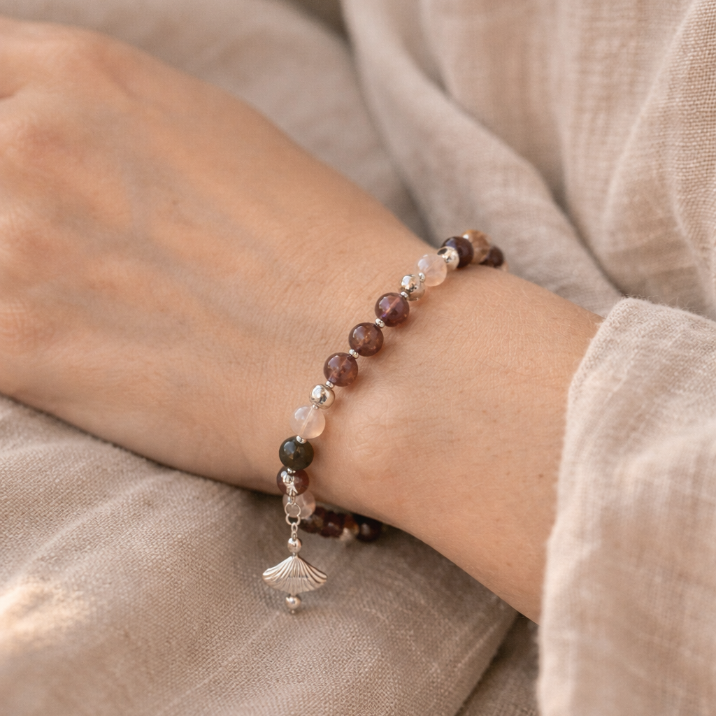 Ett handgjort Gudinne-armband med kristaller Super seven, Turmalin, Ametist och äkta silver pärlor, handknutet med HP pärltråd. Ett symboliskt smycke för balans, feminin kraft och andlighet. Design Atlantis Kristaller.